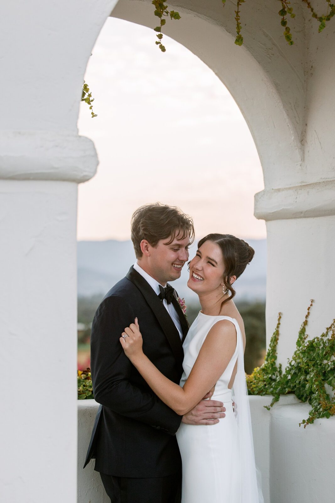 Bride and groom laughing and smiling at their Santa Ynez Ranch wedding during sunset in California