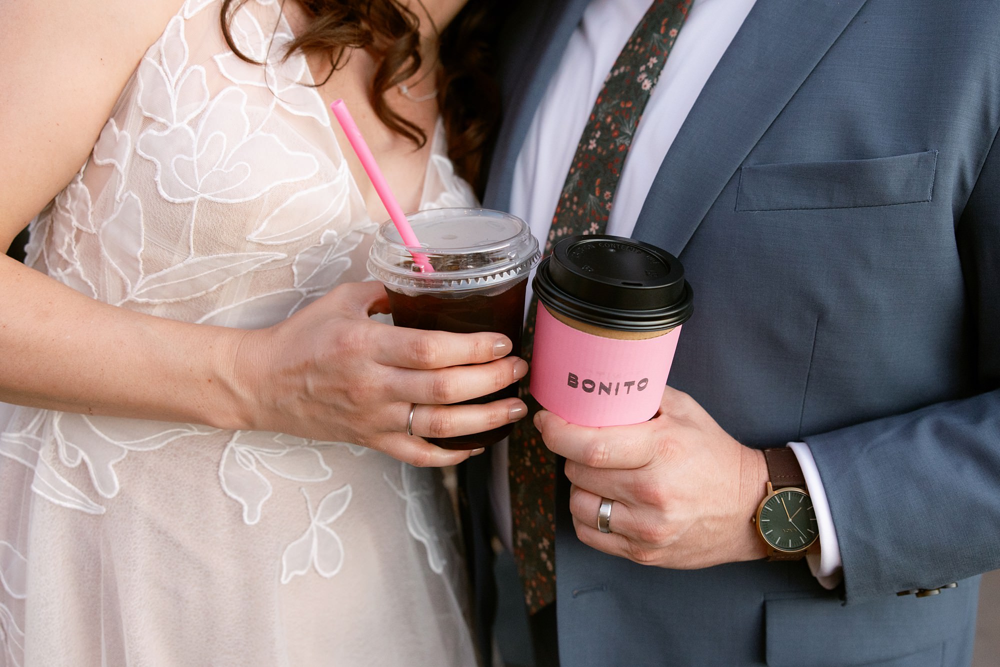 Bride and groom holding coffee